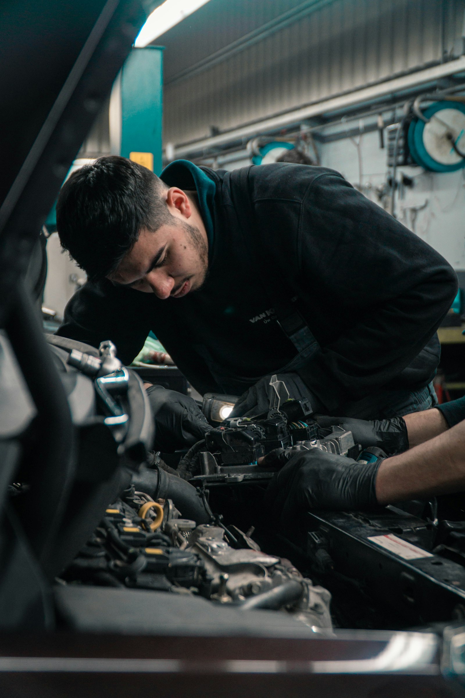 Técnico de Vulcano revisando el motor de un carro dentro del taller